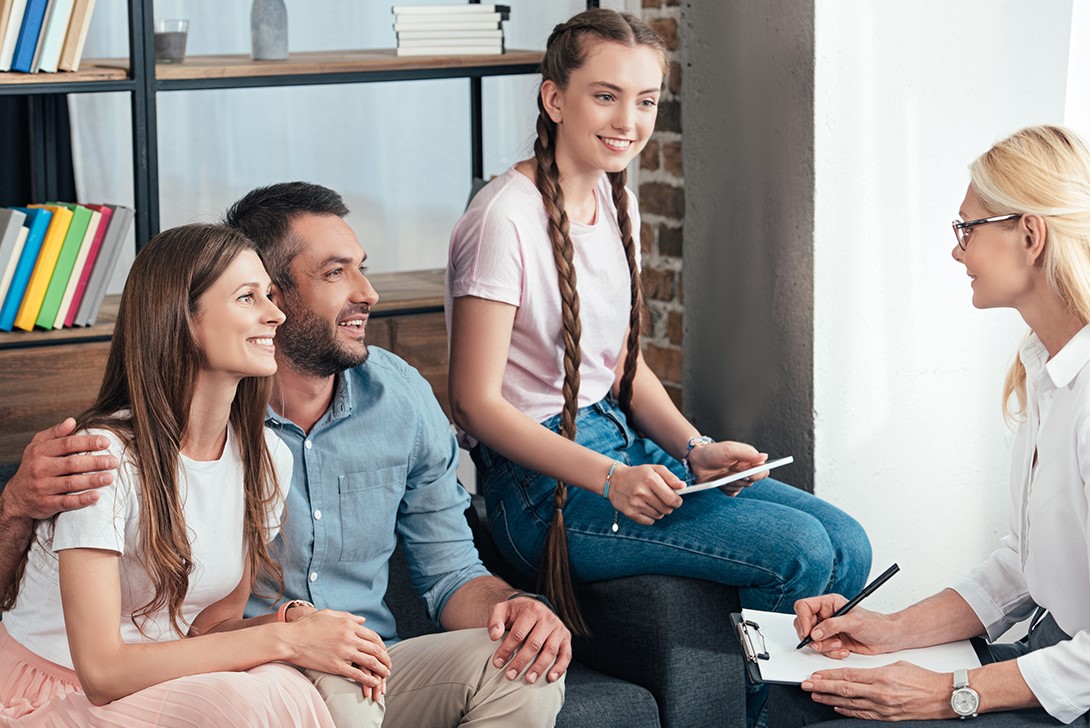 A group of people sitting around each other.